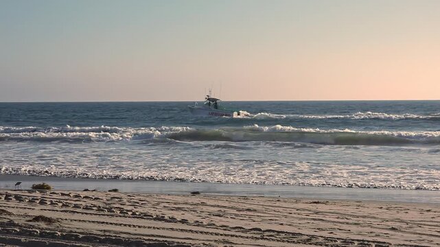 Fishing Boat Moving Through Rough Ocean Waves At Sunset, Coastal video frame with foamy surf and warm evening light over the sea