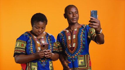 Married man and woman waving hi on web videocall network, using internet connection and video link to speak with family members. Young couple holding mobile phone to chat to people. © DC Studio