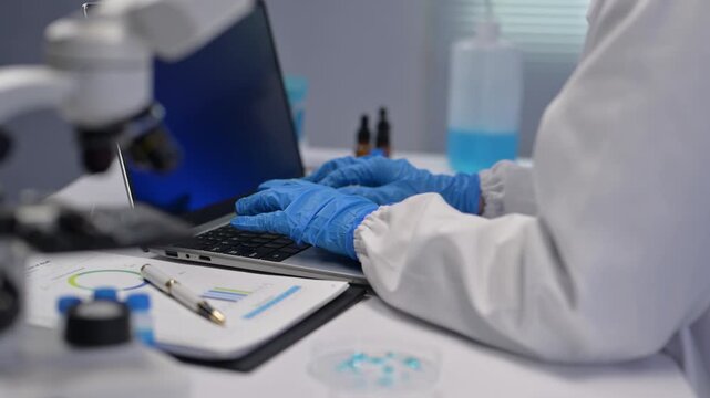 Scientist working on laptop in laboratory research setting