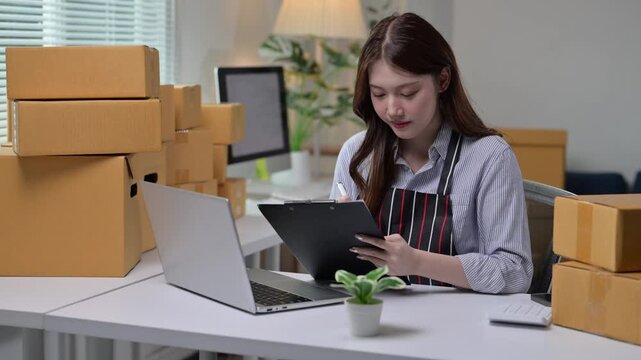 Online seller checking packages and writing customer addresses