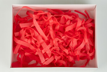 Obraz premium Shredded paper filling in a white gift box for presents