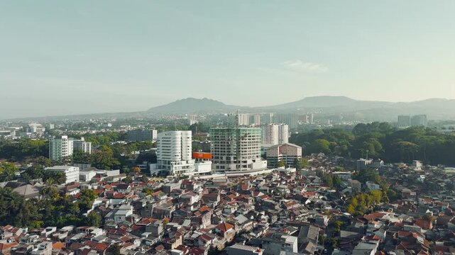 Aerial view of Bandung city in the morning, buildings and city streets with a mountain background, West Java, Indonesia, morning sunrise