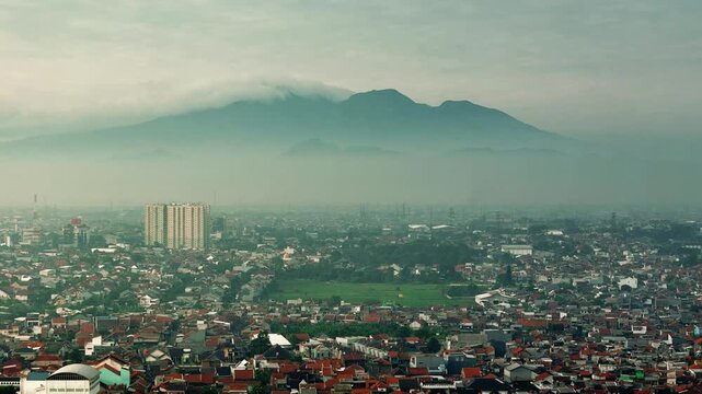 Aerial view of Bandung city in the morning, buildings and city streets with a mountain background, West Java, Indonesia, morning sunrise