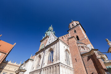 Fototapeta premium Krakow Cathedral showcases detailed architecture against a clear blue sky during midday