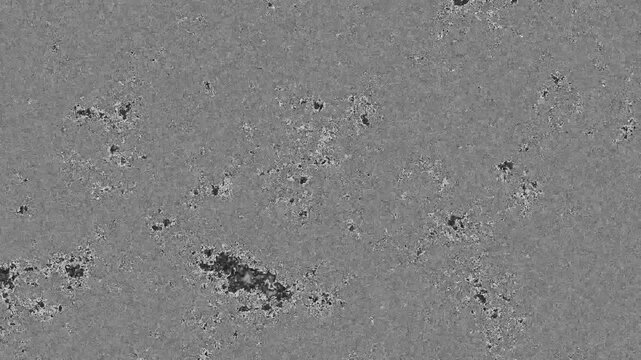 Abstract grayscale texture with scattered dark patches. Fine grain surface shows natural irregularities and subtle variations. Ideal for scientific, industrial, or minimalist design projects