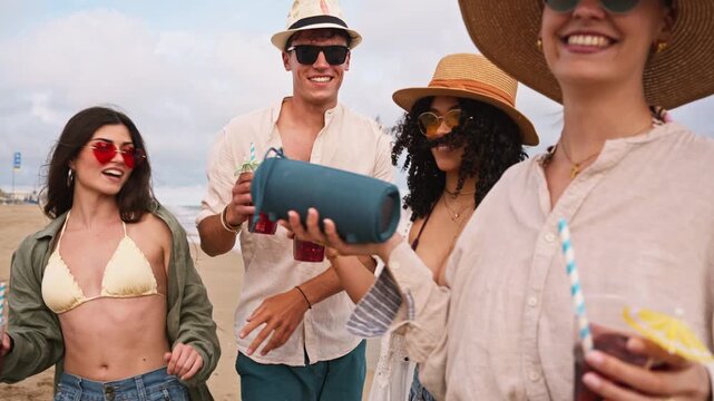 Group of happy friends dancing on the beach