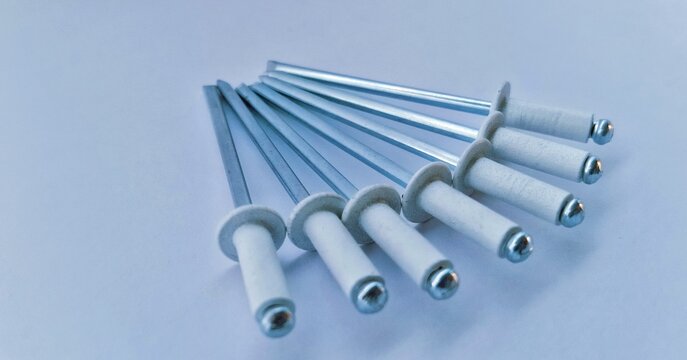 Fan Arrangement of White Aluminum Blind Rivets on White Background