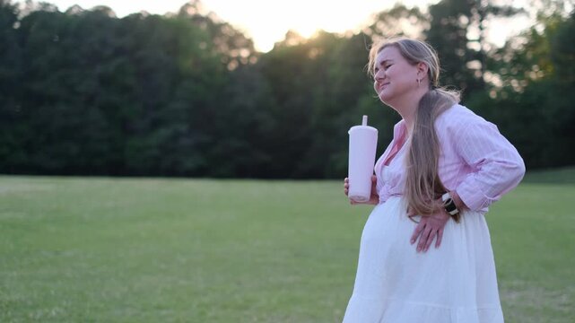 Pregnant woman experiencing painful contractions outdoors