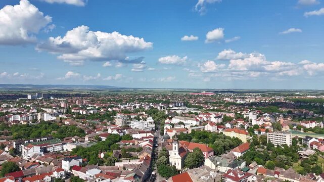 Aerial view of the historic city center of Sremska Mitrovica with red-tiled rooftops and a church tower under a cloudy blue sky, Sremska Mitrovica, Vojvodina, Serbia.