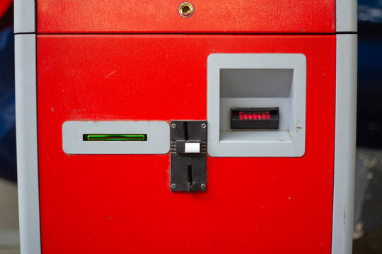 Horizontal street photo. Red ATM payment machine with gray bill and coin acceptor. Concept of plastic card, cash money, debit, credit, budget, wages, pay tax, loan, debt, control, technology, business