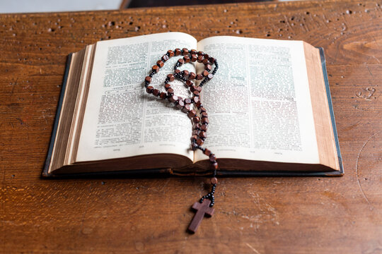 Open Bible with wooden rosary