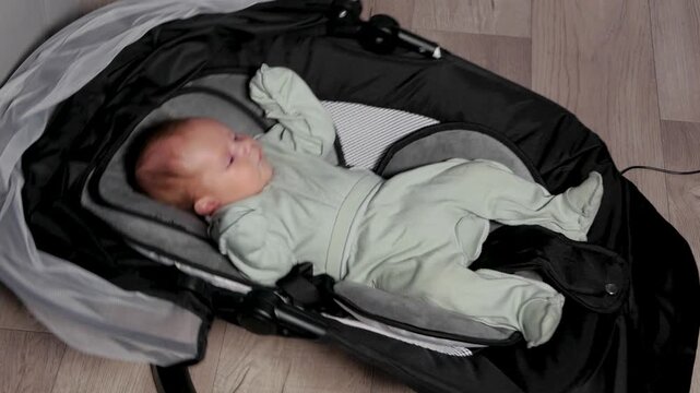Newborn baby relaxing in automatic rocking bouncer
