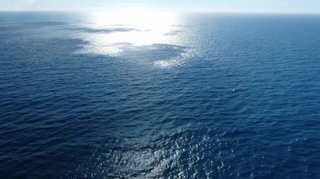 Top view of ocean with moving cloud shadows on water