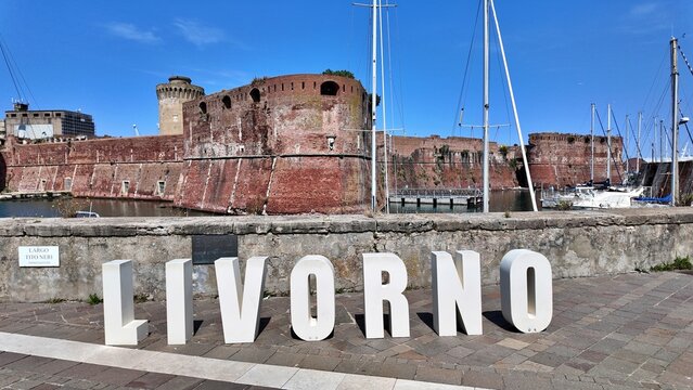 Livorno, Tuscany, Italy - 06.27.2026: view of Historic Old fortress with a moat and docked sailboats, showcasing Livorno's maritime heritage and architecture