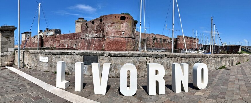 Livorno, Tuscany, Italy - 06.27.2026: view of Historic Old fortress with a moat and docked sailboats, showcasing Livorno's maritime heritage and architecture
