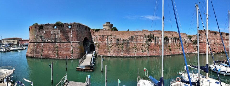 Livorno, Tuscany, Italy - 06.27.2026: view of Historic Old fortress with a moat and docked sailboats, showcasing Livorno's maritime heritage and architecture