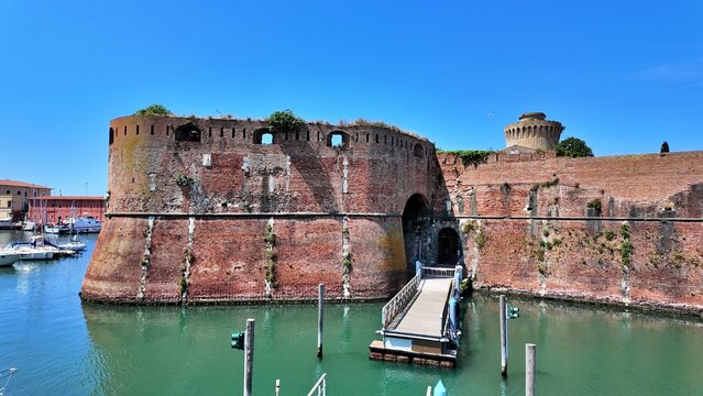 Livorno, Tuscany, Italy - 06.27.2026: view of Historic Old fortress with a moat and docked sailboats, showcasing Livorno's maritime heritage and architecture