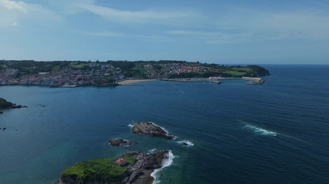 Aerial view of Luanco cityscape in Asturias Spain revealing a coastal town and bay with boats and the Isla del Carmen