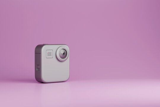 Compact action camera on purple background with copy space