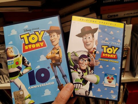 Rome, Italy - June 2, 2026, two Toy Story DVDs sit among old books in a secondhand bookstore; the famous film saga is the first animated feature film in cinema history.