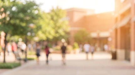 Obraz premium Blurred view of people walking on pedestrian walkway in outdoor shopping center with trees and buildings in background during sunny day with lens flare and warm atmosphere