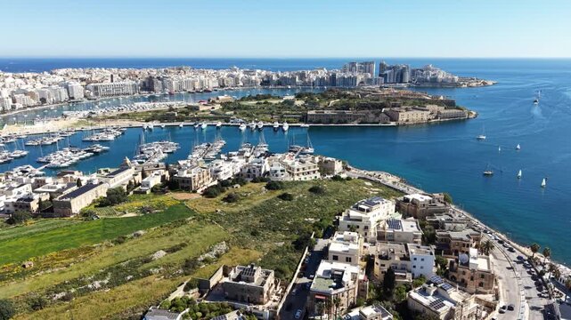 Aerial view of the marina and Manoel Island with boats docked in the harbor and historic buildings under a clear blue sky in Ta' Xbiex, Eastern Region, Malta.