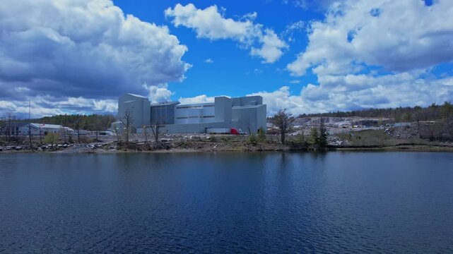 Turquoise lake water near open pit mine operation with sky. Mining operation, deep underground development of critical minerals for Artificial intelligence AI, EVs and hyperscale data centres.