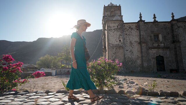Senior woman enjoys exploring the historic San Javier Mission in Loreto Baja California Sur Mexico during sunrise in the desert