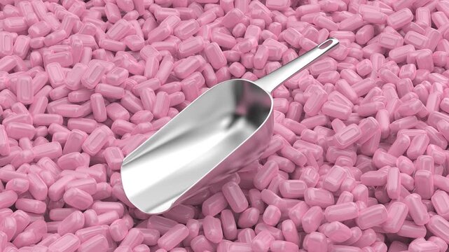 Silver metal scoop on pink hard candies