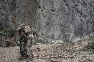 Obraz premium Soldiers assisting an injured teammate during a military field operation, demonstrating teamwork, rescue support, tactical coordination, leadership, endurance, and mission readiness in a challenging 