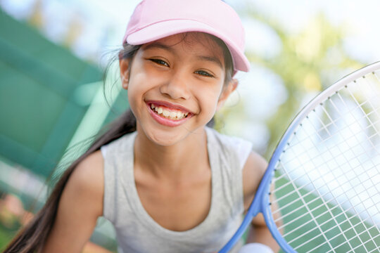 A girl is on the tennis court to play tennis.