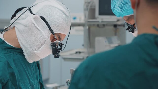 Close-up surgeons wearing protective medical gear while working in a sterile operating room environment. Professional healthcare team focused on a surgical procedure, demonstrating precision, teamwork