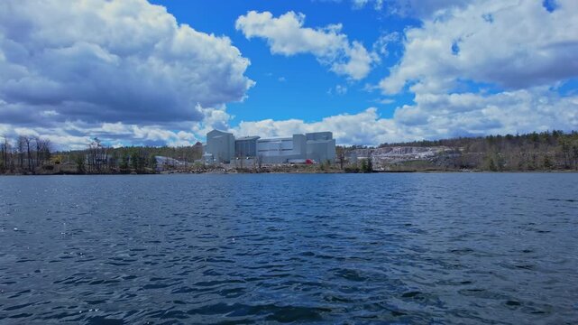 Turquoise lake water near open pit mine operation with sky. Mining operation, deep underground development of critical minerals for Artificial intelligence AI, EVs and hyperscale data centres.