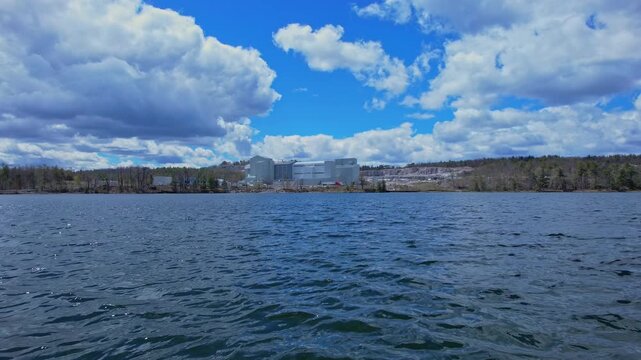 Turquoise lake water near open pit mine operation with sky. Mining operation, deep underground development of critical minerals for Artificial intelligence AI, EVs and hyperscale data centres.