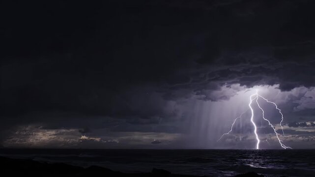 Lightning Strikes Over Ocean During Stormy Weather - Multiple lightning bolts illuminate the dark, cloudy sky over the ocean horizon.