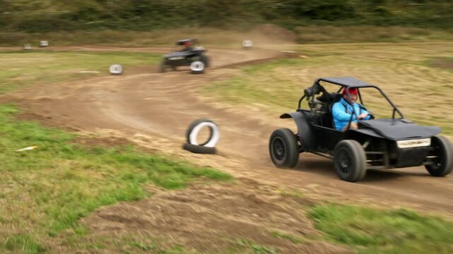 Thrilling off road buggy race on a dusty dirt circuit with a driver competing at high speed