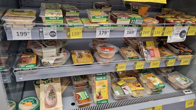 Ready-made salads and prepared meals in supermarket refrigerator display, convenience food concept