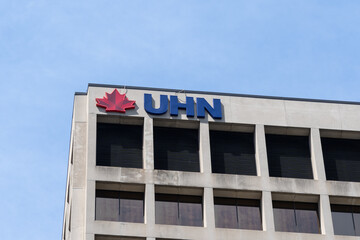Naklejka premium Toronto, Ontario, Canada - June 2, 2026: Closeup of UHN logo on top of the Princess Margaret Cancer Centre building on University Avenue in Toronto, Ontario, Canada. UHN is recognized as the Canadian