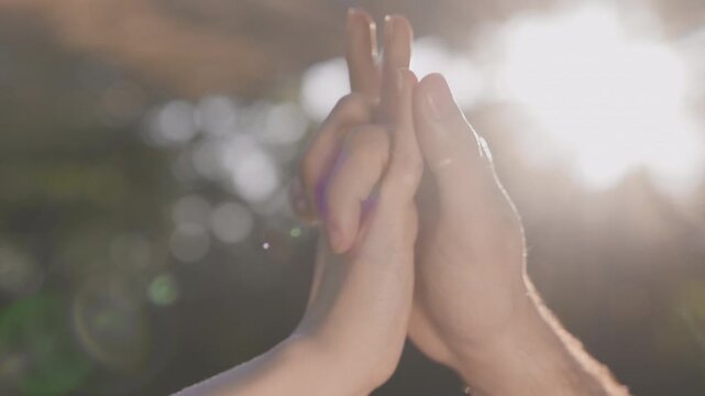 Close-up of two people touching hands in warm sunlight outdoors. Symbol of human connection, trust, support, care, friendship and emotional bonding. Relationships, togetherness, comfort and positive