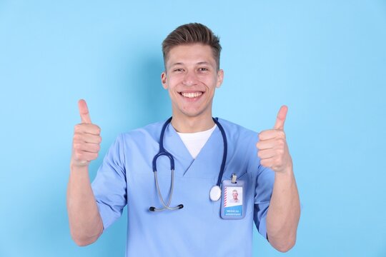 Medical assistant showing thumbs ups gesture on light blue background