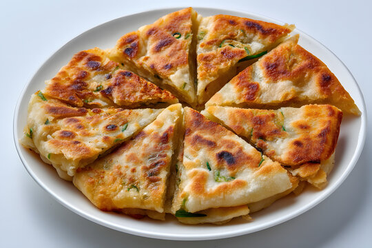 Delicious Northern Chinese Cong You Bing Served on a White Plate with Crispy Golden Brown Edges and Herbs
