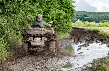 Fototapeten Extremsportarten ATV Rider Splashing Through Muddy Off Road Trail Extreme Quad Bike Adventure in Countryside Landscape. Dynamic Action Photograph. Outdoor Motorsport.  © Nomad Pixel