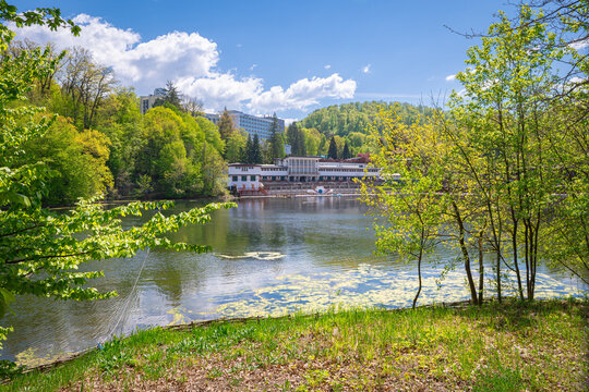 Peaceful lakefront pavilion surrounded by forest trees on a sunny spring day at Bear Lake in Sovata, Romania