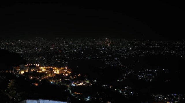 Night timelapse view of Dehradun city captured from the hills of Mussoorie, Uttarakhand, India. Long exposure light trails and vibrant illumination highlight the dynamic energy of the city at night.