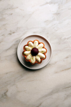 Flower shaped lemon tart dessert on a ceramic plate