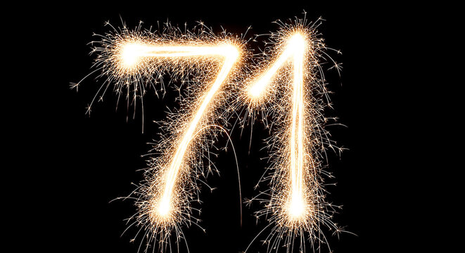 Vibrant sparklers arranged in a glowing, dynamic display to create the number 71 against a dark background, evoking celebration and festivity.