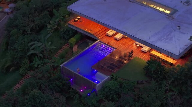 In a beautiful Costa Rican house, a father and son enjoy precious moments by their stunning pool, experiencing peace, happiness, and tranquility together amidst lush greenery