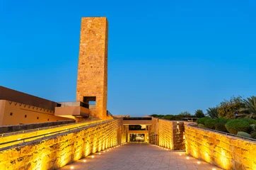 Sheikh Muhammad ibn Abd al-Wahhab Mosque with a beautifully illuminated stone tower and walkway in Diriyah, Riyadh, Saudi Arabia during blue hour © Leonid Andronov