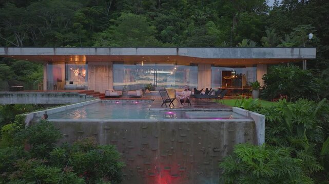 This stunning aerial view highlights a modern house in Costa Rica, featuring a gorgeous swimming pool surrounded by lush greenery, enhancing its beauty and offering a tranquil retreat