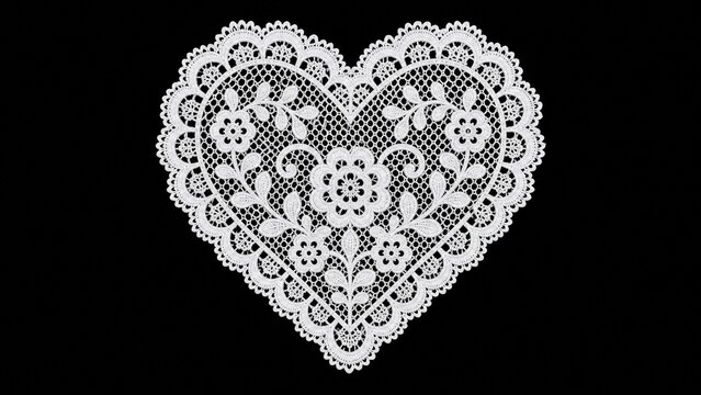 White heart shaped lace doily with floral embroidery isolated on black backgrounding.